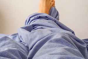 Feet under blanket in peaceful rest scene, a Health & Medical Photo by DanFLCreativo