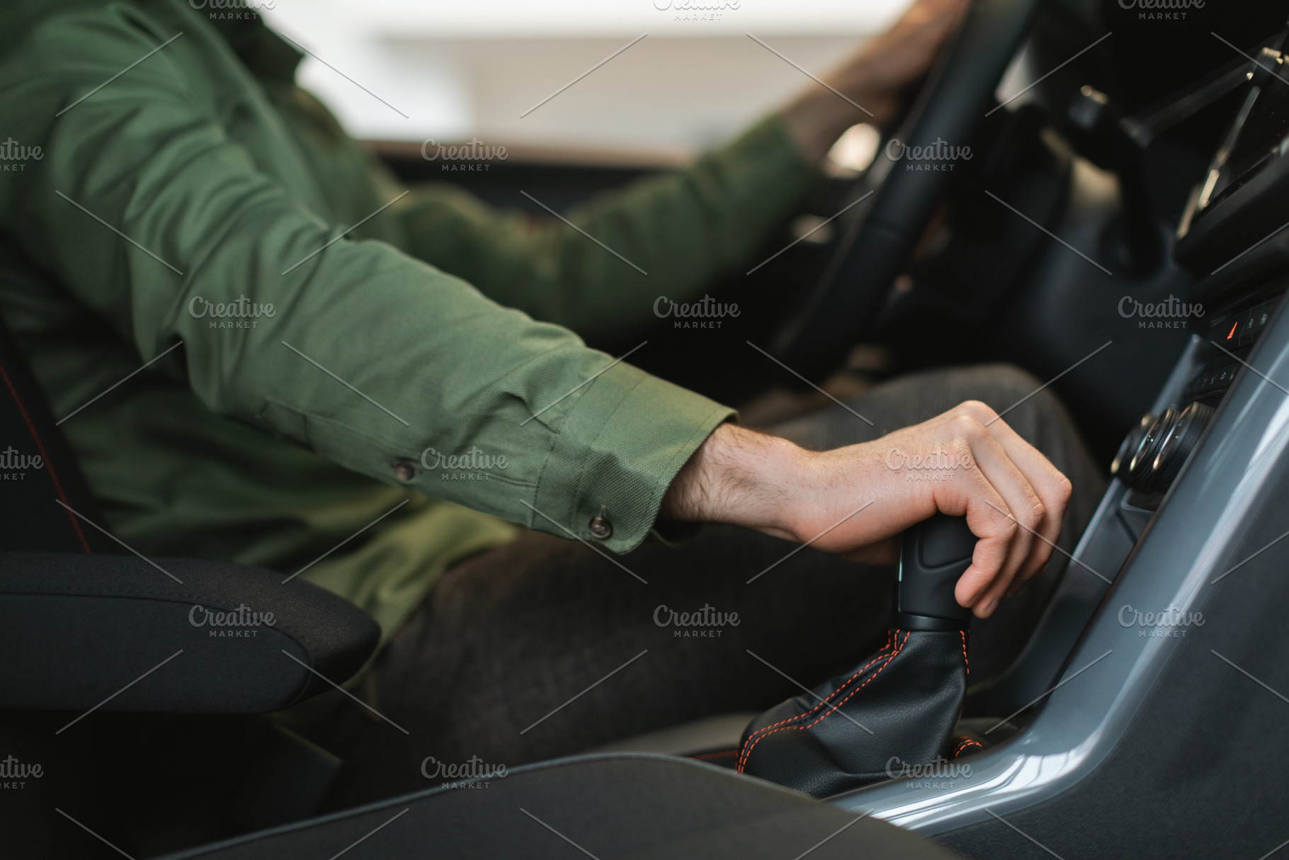 Unrecognizable young guy checking manual transmission in new car, going on test, a Photo by Prostock-Studio