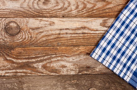 Blue checkered tablecloth on the old wooden table with copy space for your, an Abstract Photo by NataPhoto