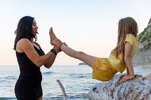 Playful mother and daughter enjoying time together by the sea, smiling and maki, a Person Photo by Ales Munt