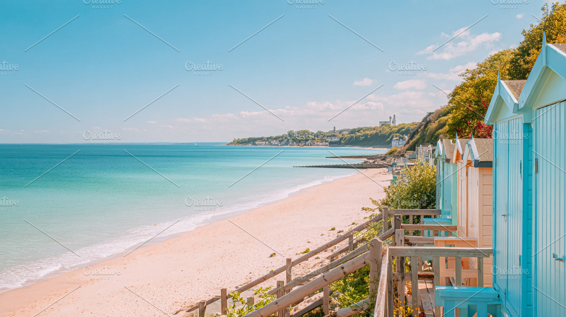 Beach huts lining a sandy shore with turquoise ocean under a cle, a Photo by Studio ANNA