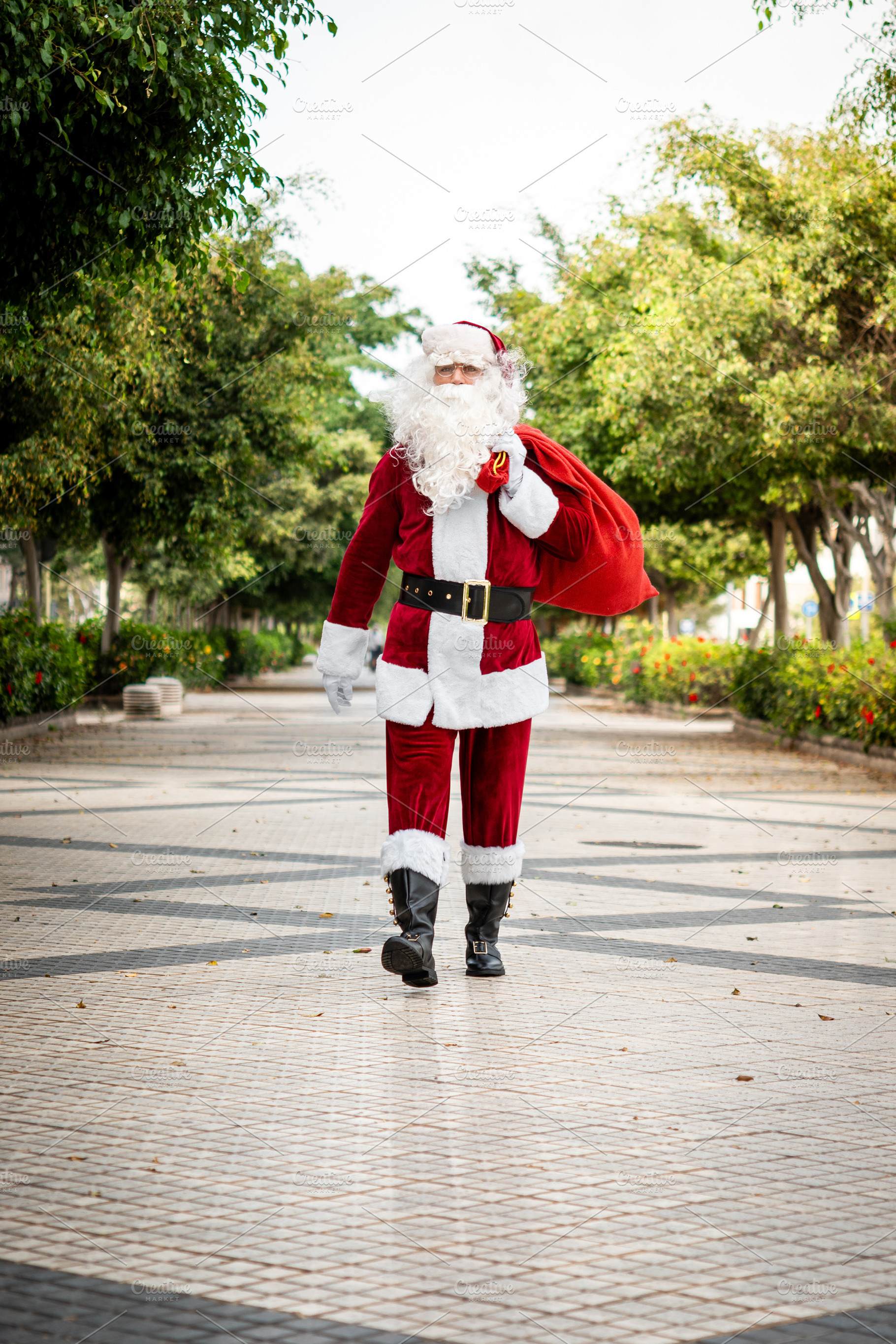 Santa Claus walking outdoors carrying large Christmas gift sack, a Person Photo by etorres69