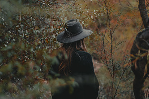 Girl in trees containing green, bush, and bushes