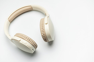 Modern wireless headphones lying on white background, a Technology Photo by Olena Rudo