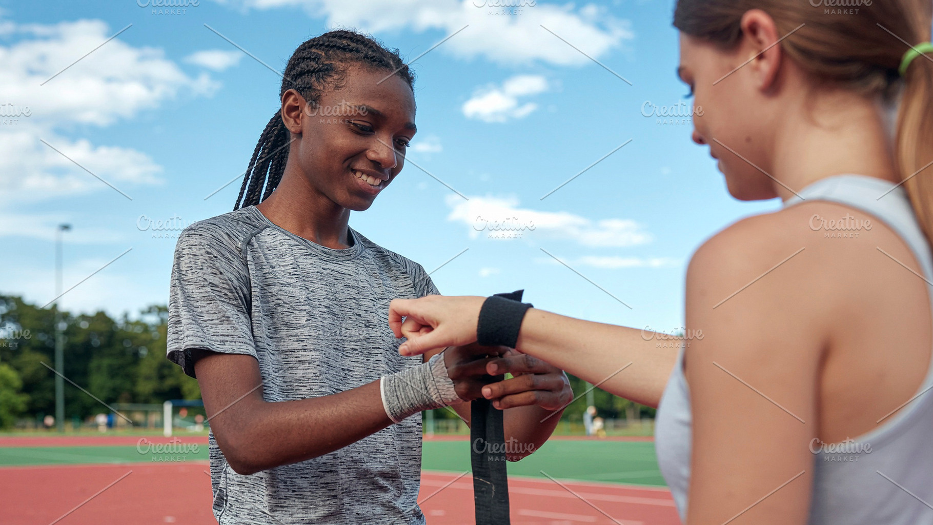 Two female runners adjusting bandages on track, a Photo by DanFLCreativo