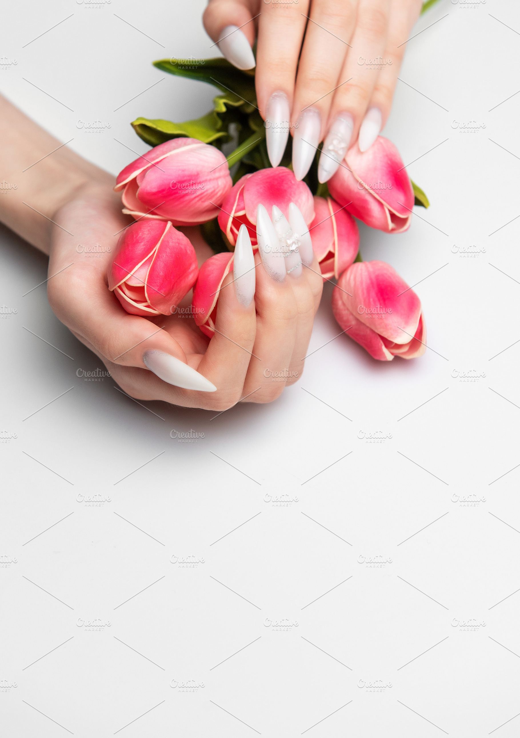 Woman's hands with long white nails holding tulips, a Beauty & Fashion Photo by Olena Rudo