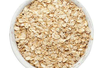 Raw oatmeal in a white wooden bowl on a white background, a Food & Drink Photo by ndanko