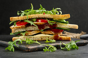 Grilled chicken sandwich with fresh tomatoes, cucumbers, arugula, a Food & Drink Photo by ndanko