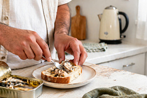 Man preparing sardine sandwich in co, a Photo by Dvoevnore photos