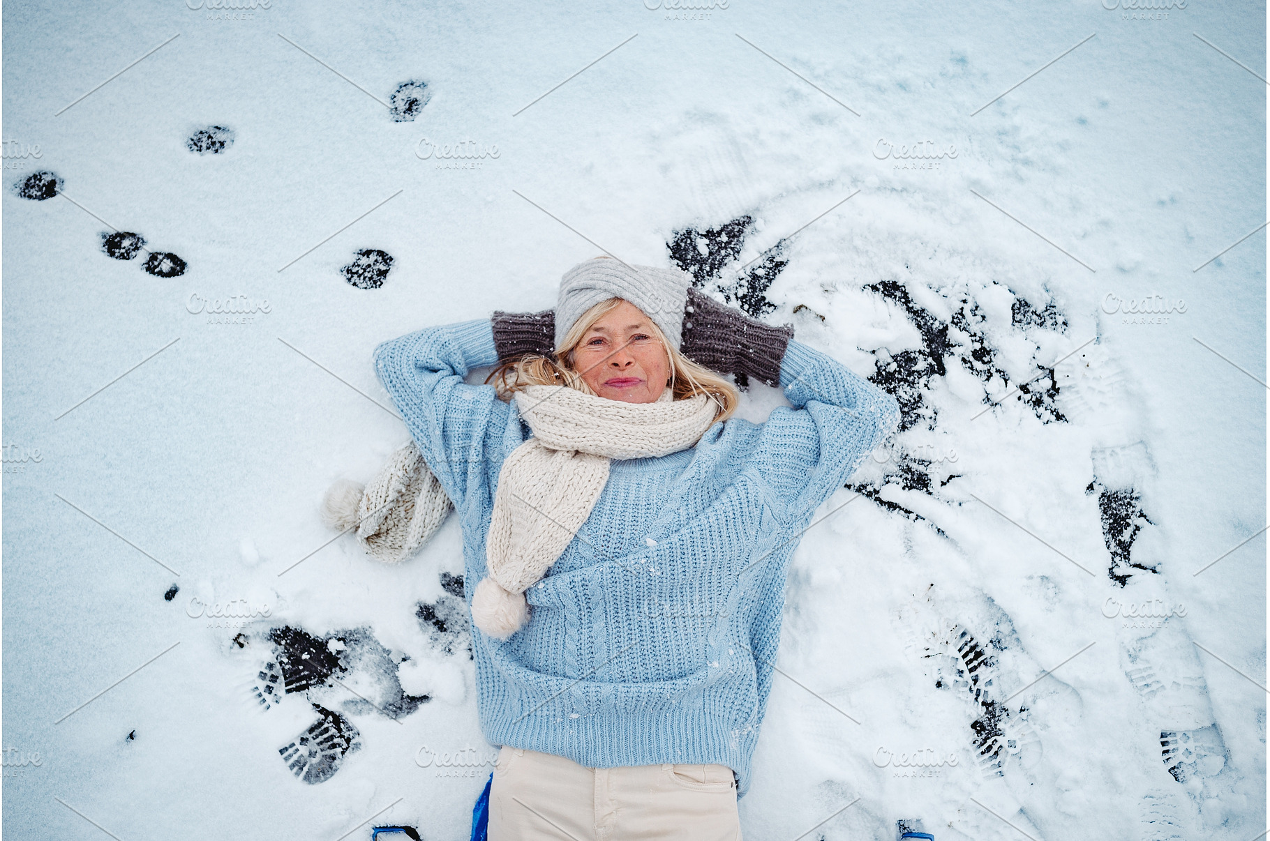 Older woman lying in show, enjoying, a Holiday Photo by HalfPoint