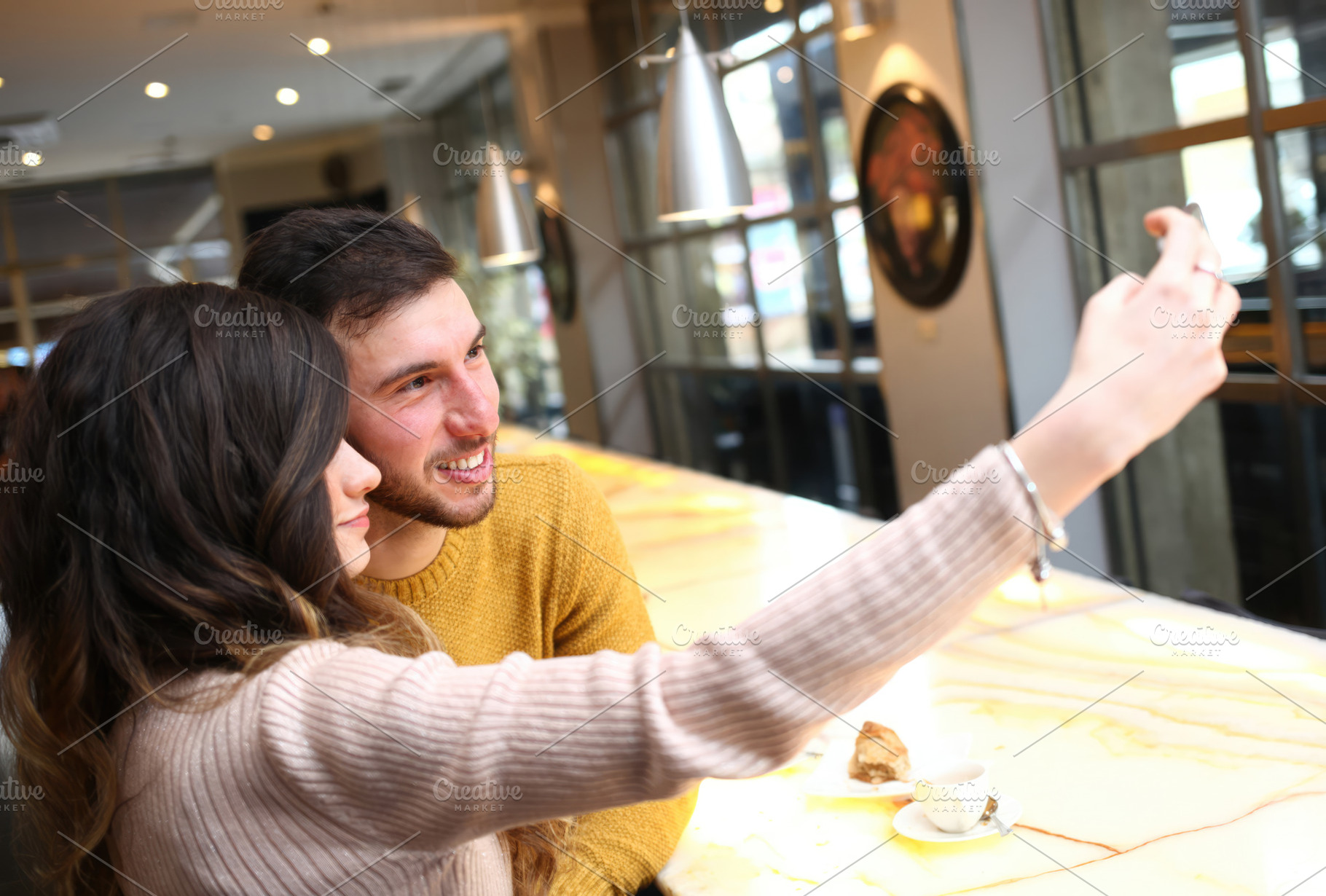 Young couple taking a selfie in a bar with smartphone, an Abstract Photo by Antonio Gravante Market