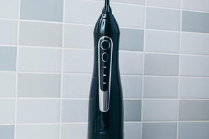 closeup of an oral irrigator in a bathroom, a Photo by Nito