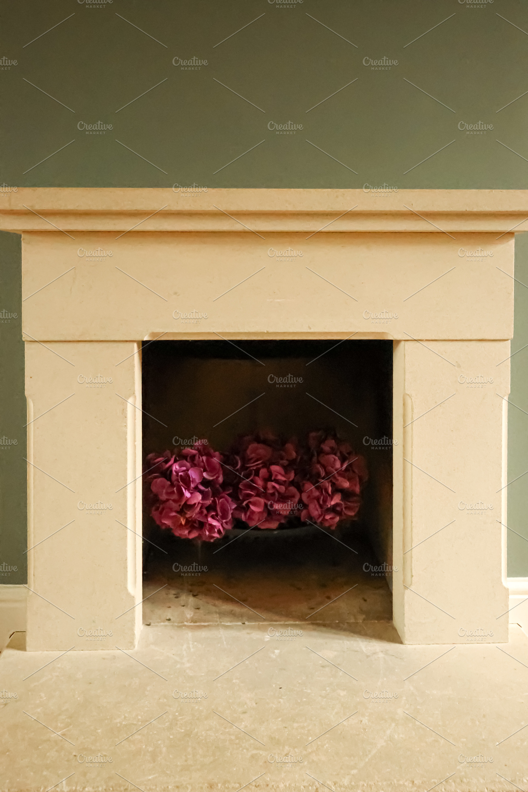Stone fireplace featuring vibrant faux pink hydrangea flowers, enhancing an ele, a Photo by Studio ANNA
