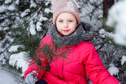 Little girl in a bright jacket plays in the winter forest, a Person Photo by Olena Rudo