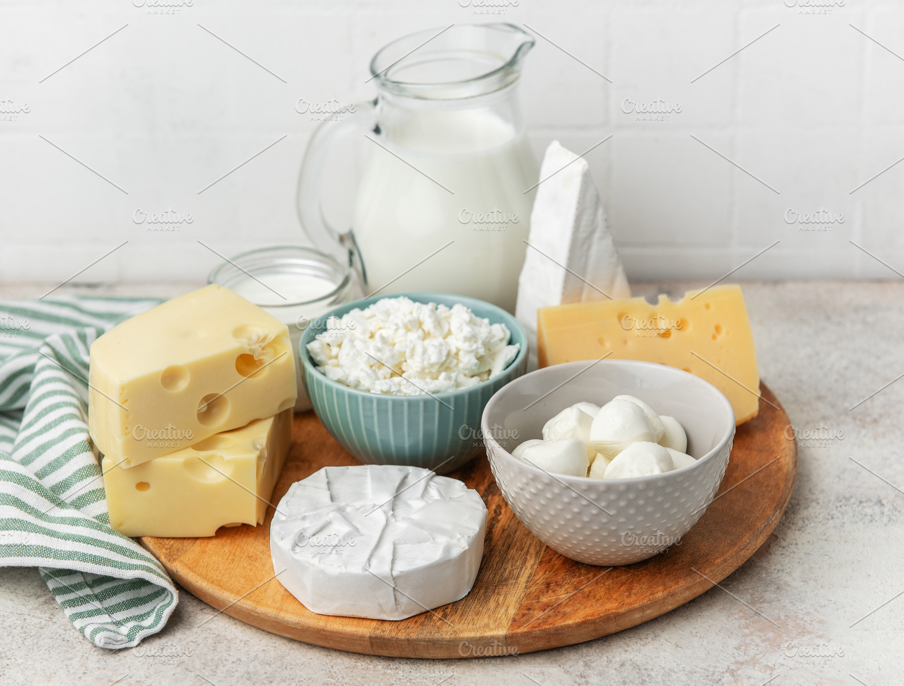 Assortment of fresh dairy products on wooden board, a Food & Drink Photo by Olena Rudo