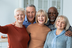 Positive senior people taking selfie together, kitchen interior, a Photo by Prostock-Studio