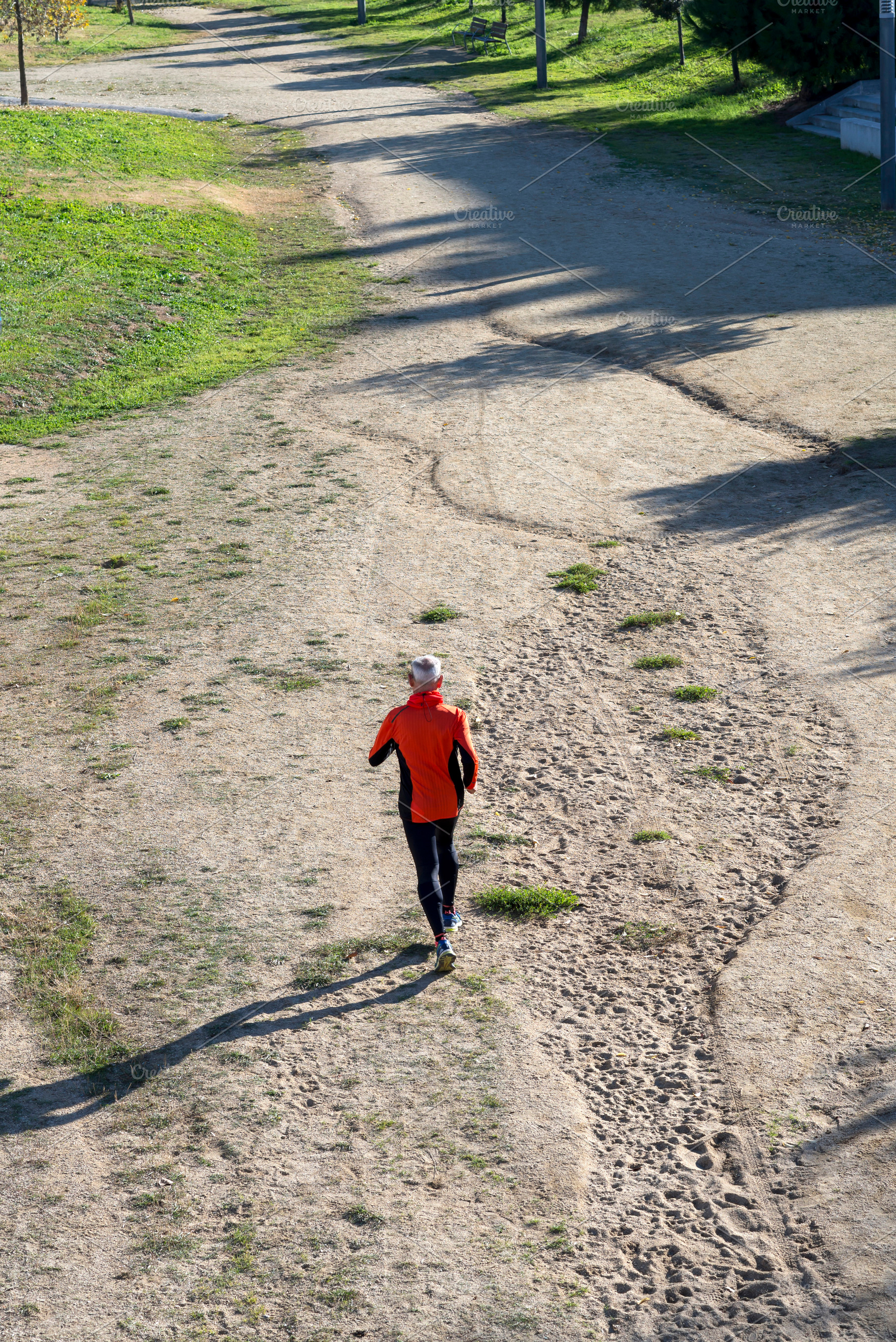 Senior man running on dirt trail from aerial perspective, a Sports & Recreation Photo by RF Images
