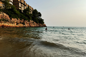 Beachside cliff view with swimmers in Salou, Tarragona, Catalonia, Spain, a Photo by AS photostudio
