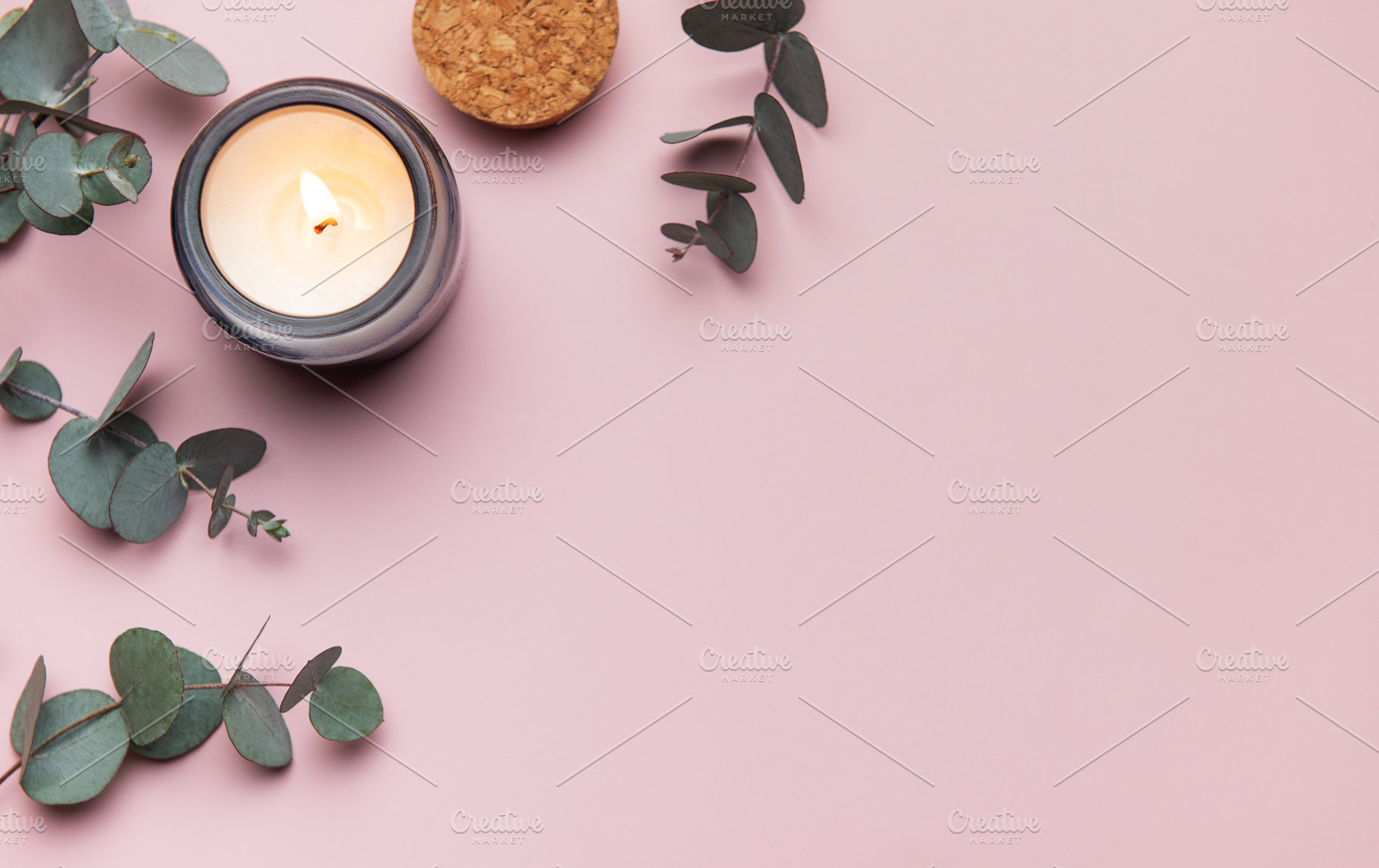 Burning aromatic candle with eucalyptus branches on pink backgro, a Business Photo by Olena Rudo