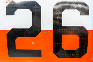 Black number -26- on an old aircraft fuselage with riveted panel, a Transportation Photo by GoodGoods