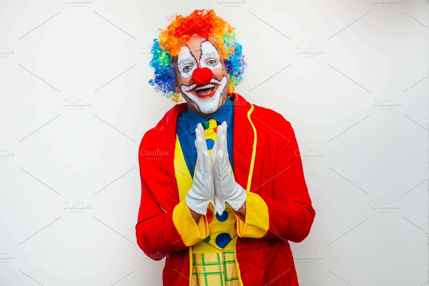 Smiling clown with hands together, a Person Photo by karrastock