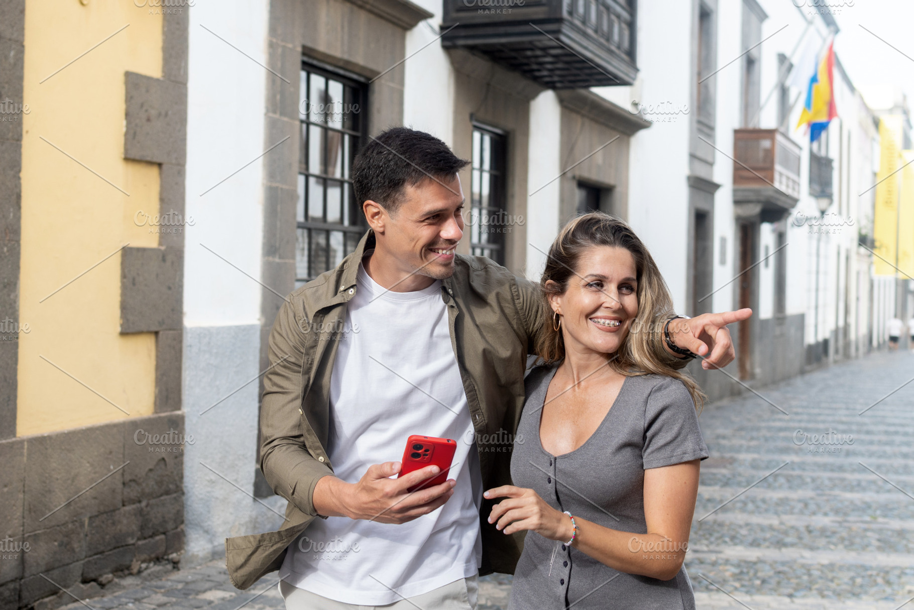 Tourist couple pointing at attractions while exploring old town, a Person Photo by etorres69