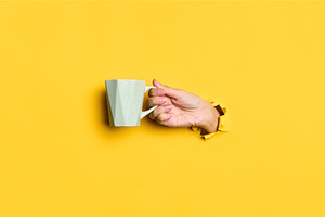 Female hand holding cup on yellow, a Food & Drink Photo by Gladkov photography