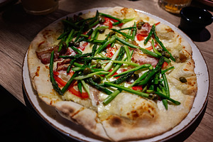 Delicious freshly prepared gourmet asparagus pizza topped with vibrant vegetabl, a Photo by AS photostudio