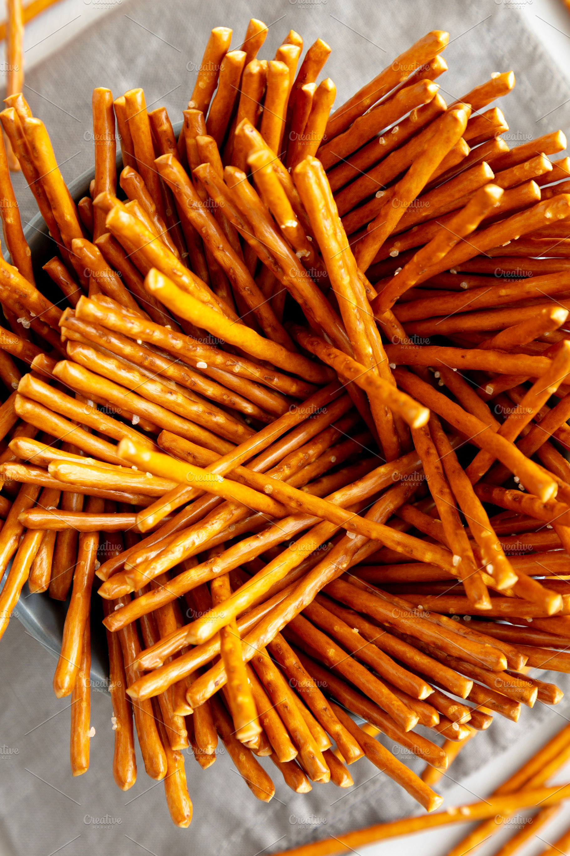 Organic Salty Pretzel Sticks in a Bowl, top view., a Food & Drink Photo by LiudmylaChuhunova