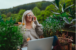Mature woman sitting on balcony, a Person Photo by HalfPoint