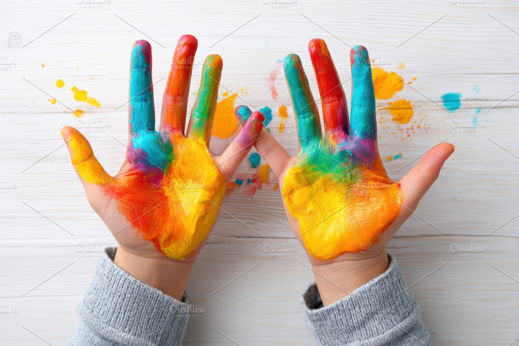 Colorful painted hands with blue and orange paint, an Arts & Entertainment Photo by AlyaAnd