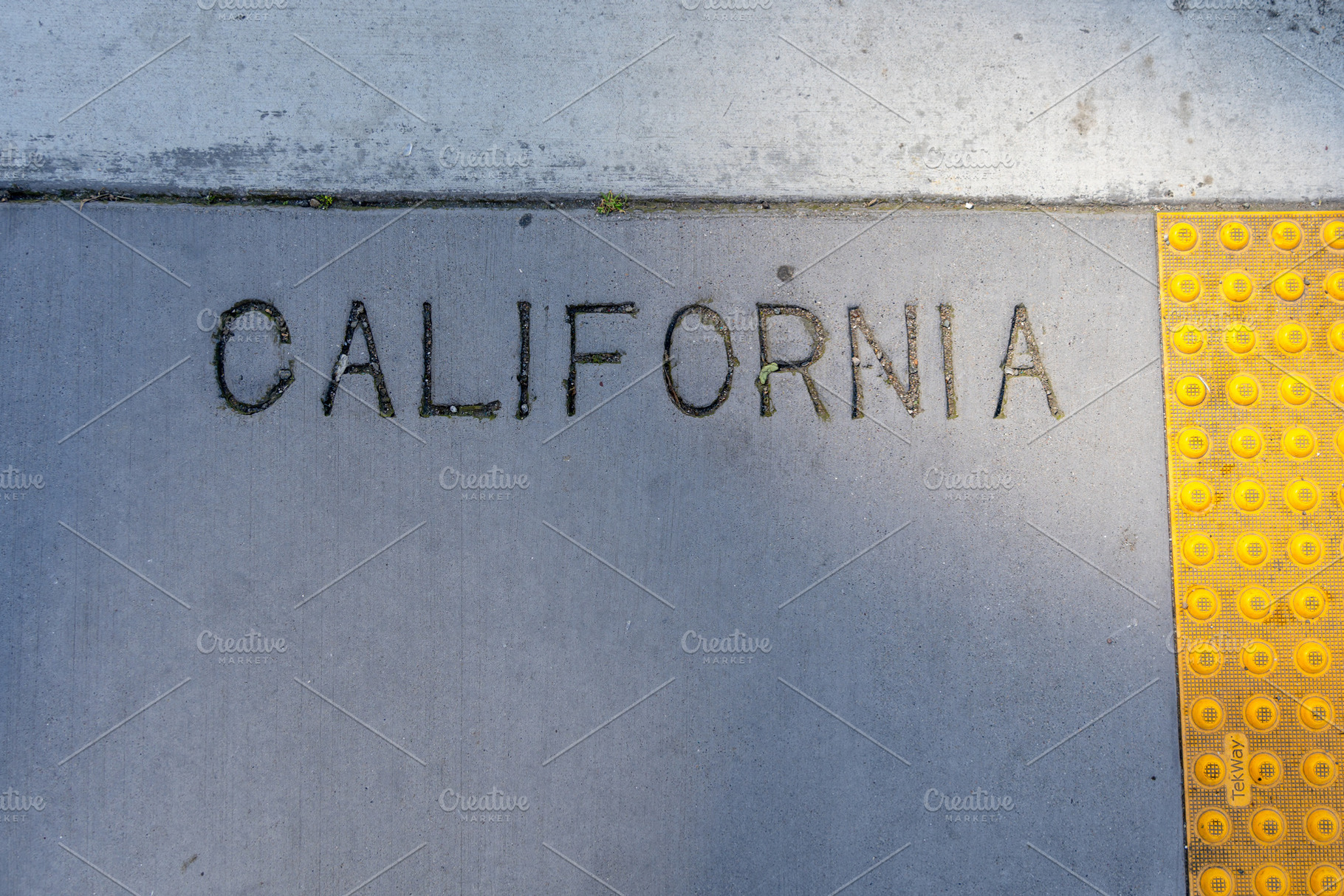 Engraved California text on a concrete sidewalk in San Francis, a Background Photo by GoodGoods