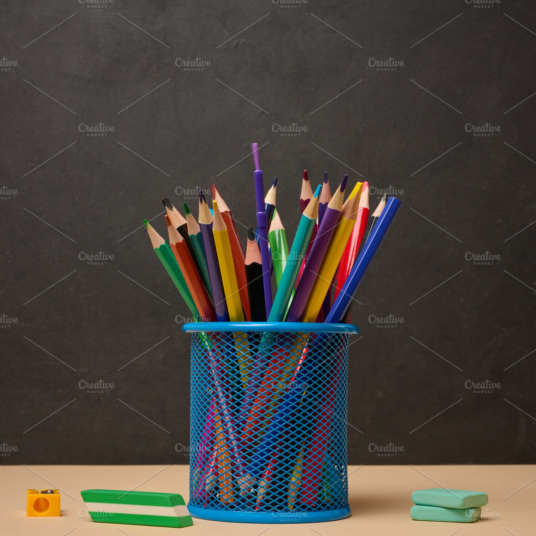 Multi-colored pencils in a blue metal cup, sharpener and erasers, a School & Education Photo by ndanko