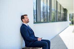 Handsome businessman in suit sitting, a Business Photo by HalfPoint