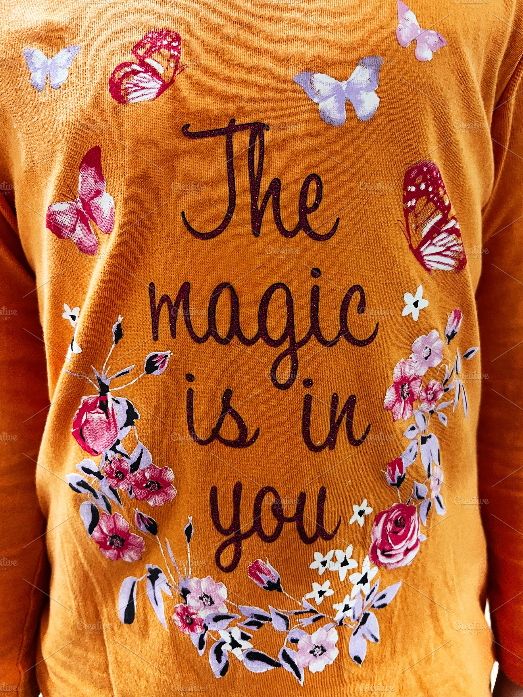Orange shirt with motivational text The Magic Is In You surrounded by flowers a, a Photo by AS photostudio
