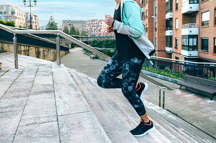 Woman training cardio running up stairs in town