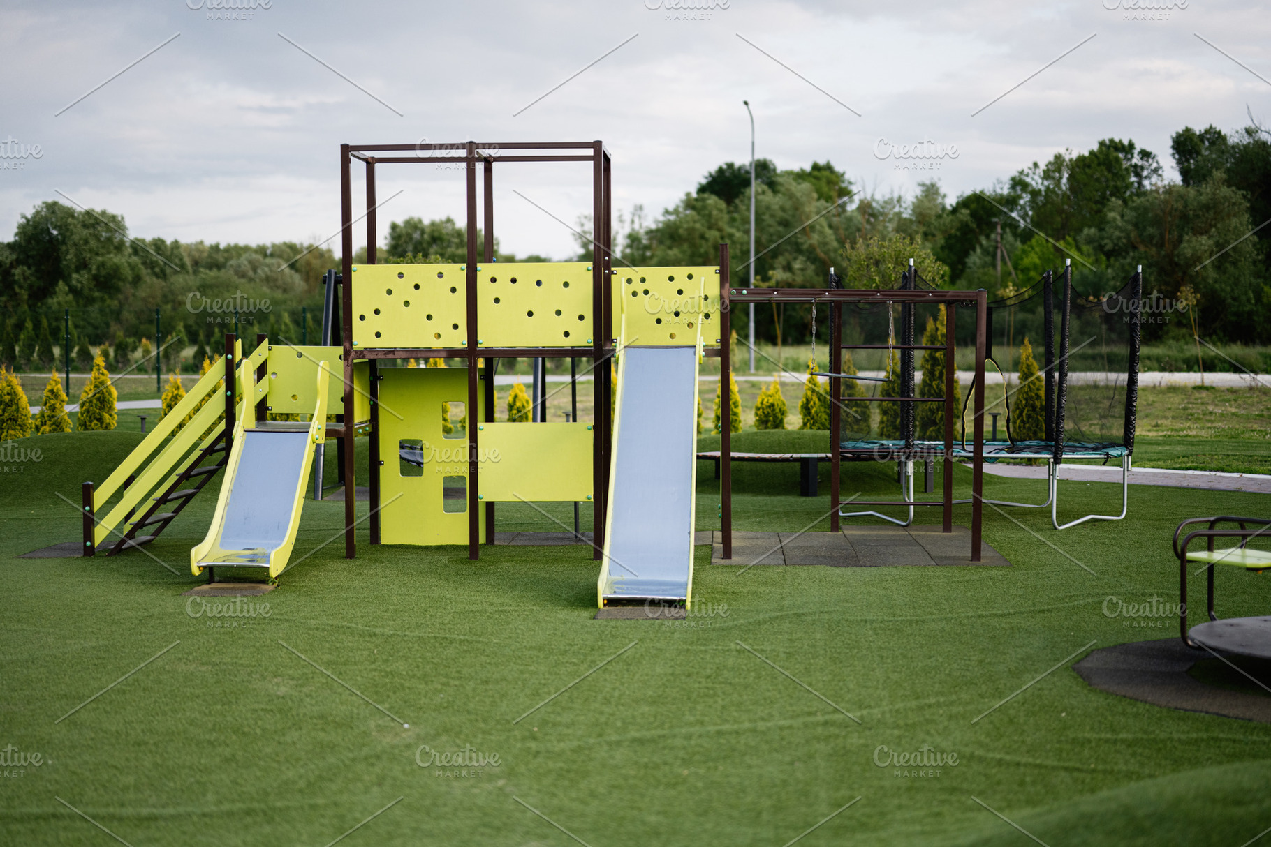 Playground equipment with slides and ladders on an artificial grass surface, a Photo by AS photostudio