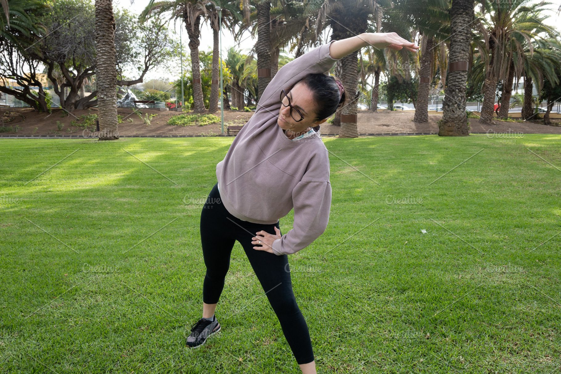 Woman doing side stretch exercise outdoors in a park, a Person Photo by etorres69