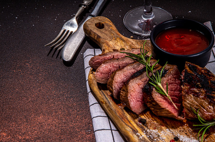 Grilled meat steak on dark table, a Food & Drink Photo by Rimma
