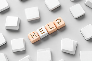 Unique keyboard keys spelling out help surrounded by blank keys on a simple sur, a Photo by AlyaAnd
