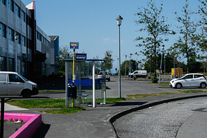 A bus stop in Akranes, Iceland with a clear sky and nearby park, a Photo by AS photostudio