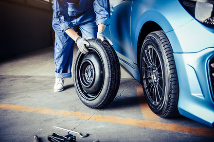 Car mechanics changing tire at auto repair shop garage. Transpor, an Industrial Photo by Ministocker