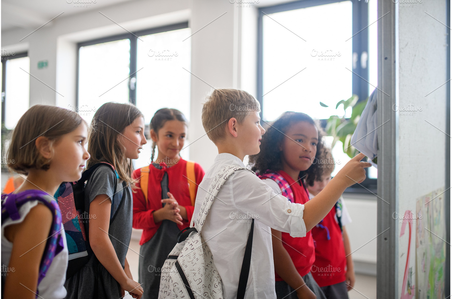 Group of schoolchildren looking at, a School & Education Photo by HalfPoint
