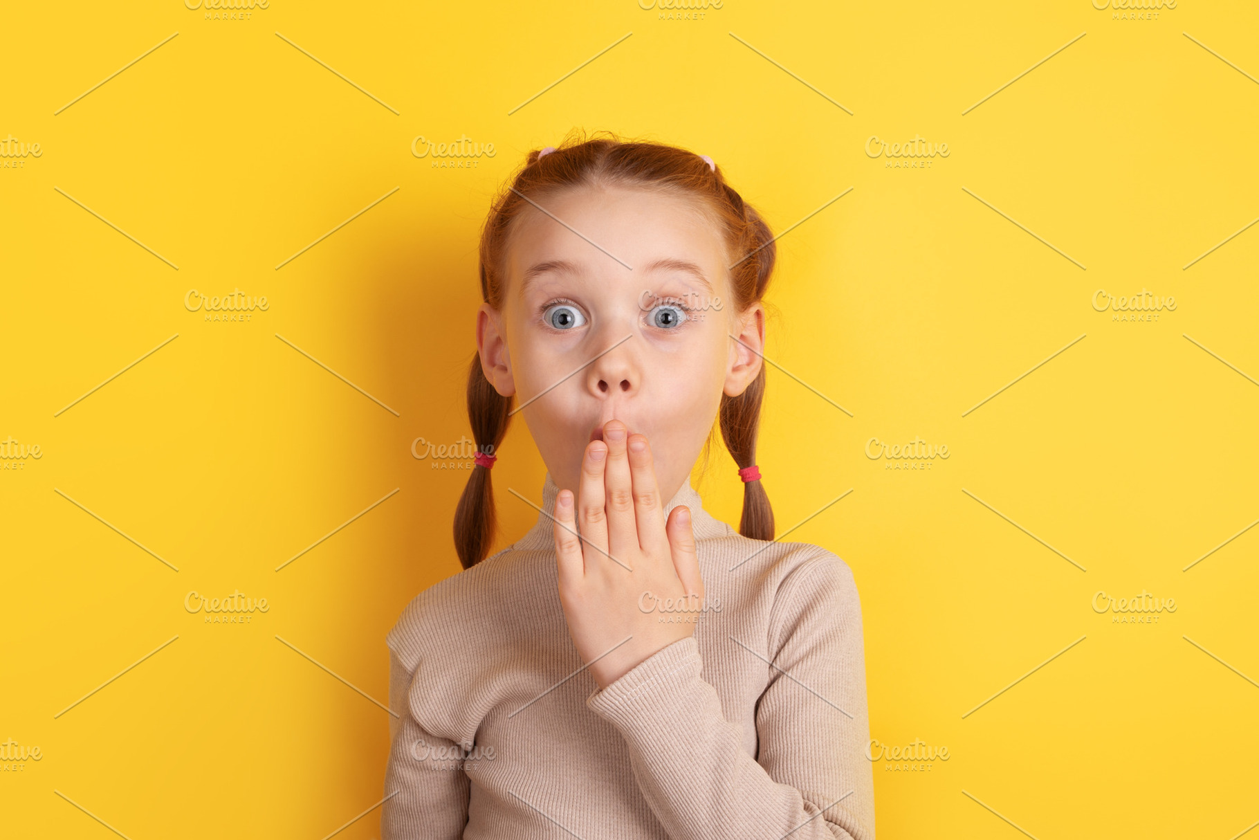 Portrait of a young girl with pigtails expressing surprise, hand, a Person Photo by Ales Munt