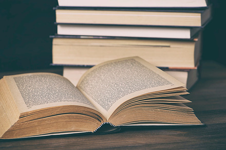 Open book next to several stacked books. Antiquity., a School & Education Photo by José Luis Agudo