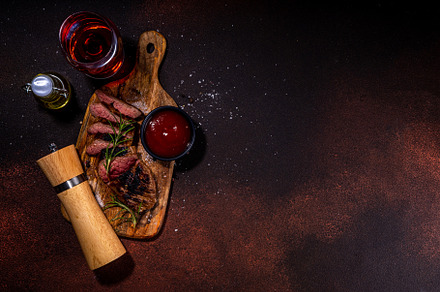 Grilled meat steak on dark table, a Food & Drink Photo by Rimma