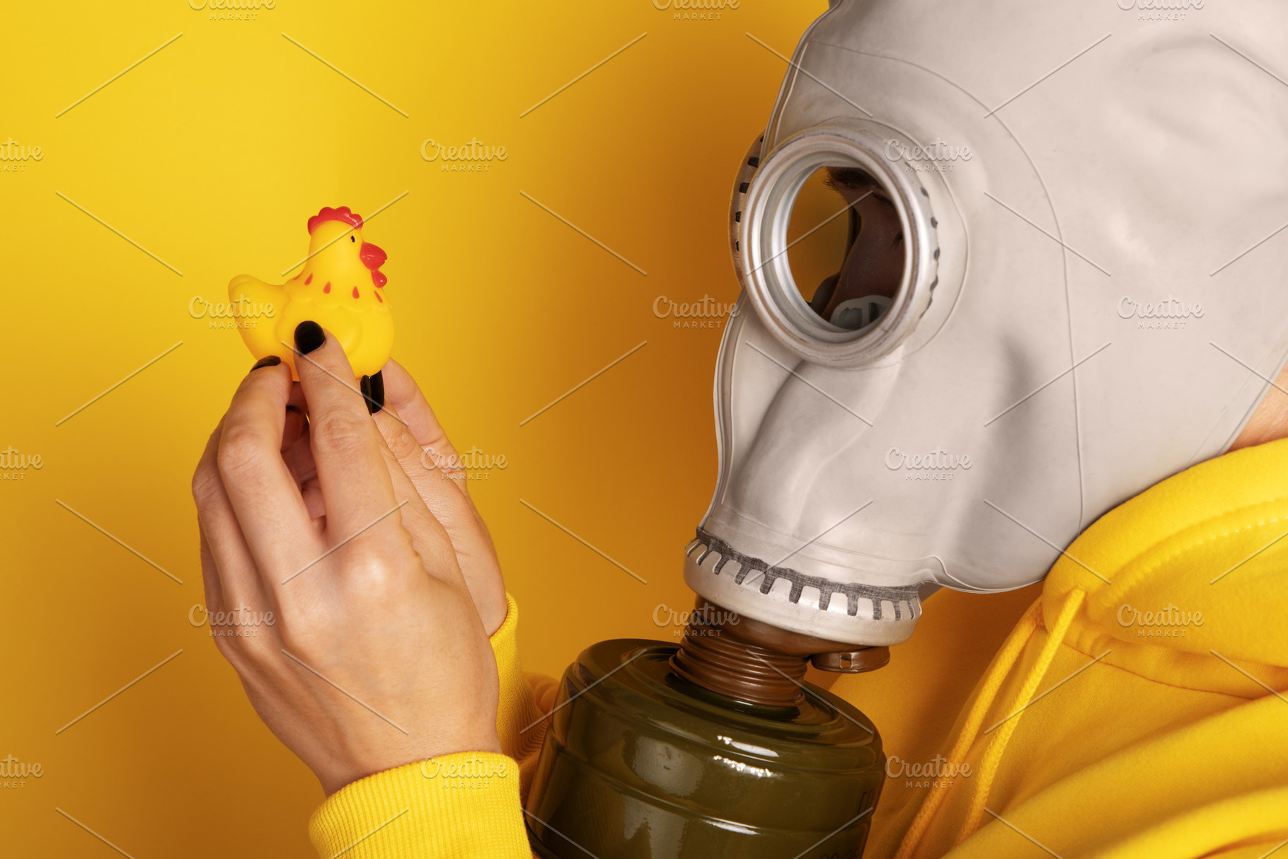 Close-up of a person in a gas mask examining a yellow rubber chi, a Person Photo by Ales Munt