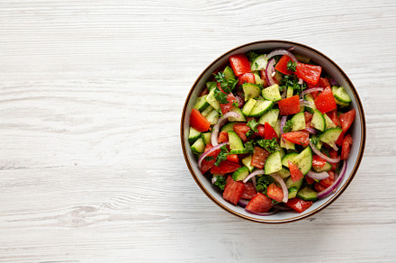Homemade Mediterranean Cucumber Tomato Salad in a Bowl, top view, a Food & Drink Photo by LiudmylaChuhunova