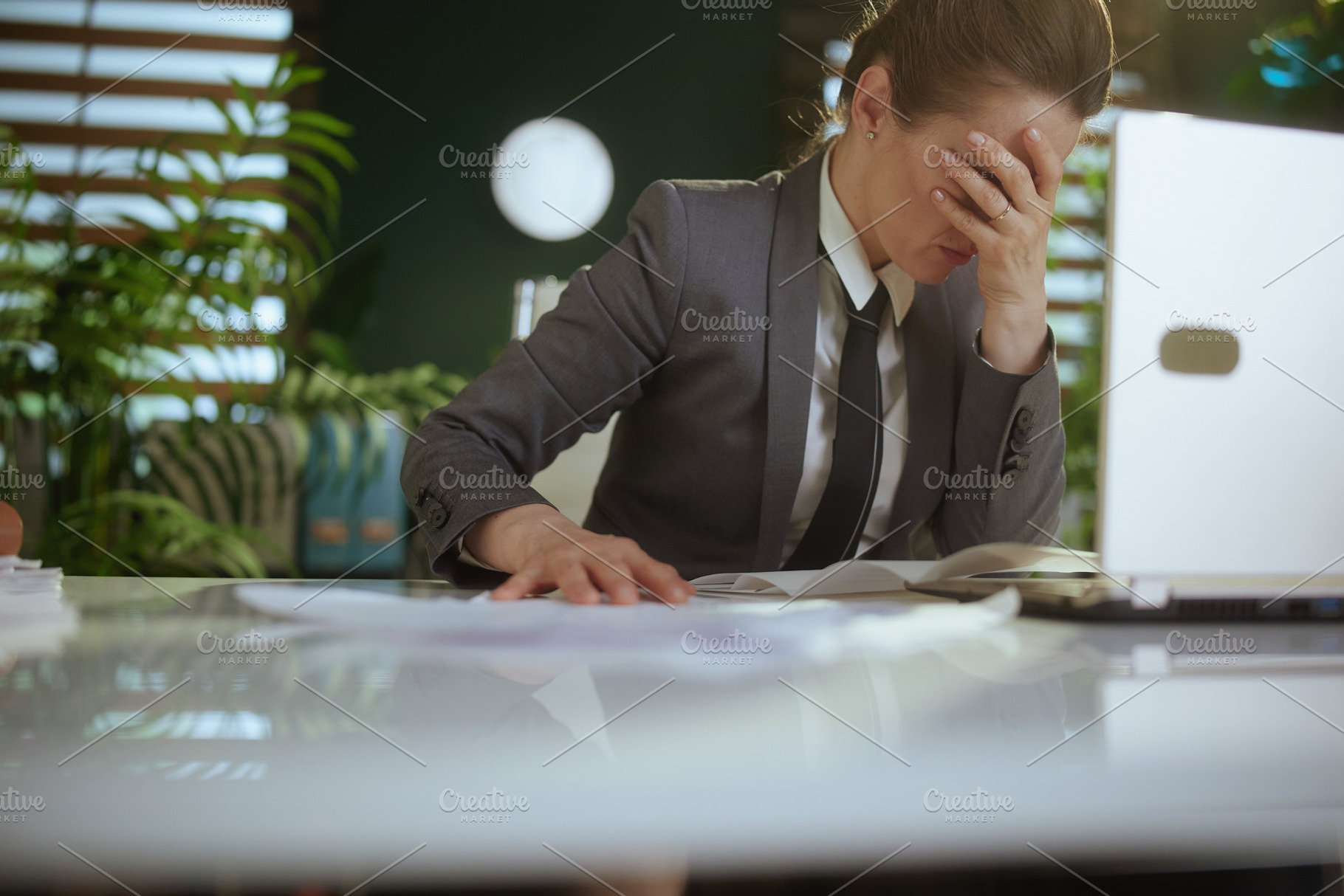 unhappy woman worker in green office throwing documents, a Business Photo by Alliance Images