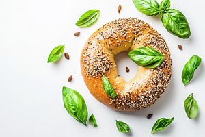 Sesame bagel topped with basil, a Photo by Pavel_design